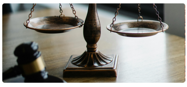 Scales of justice and gavel sit on a desk