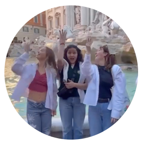 三个学生从肩上往喷泉里扔硬币